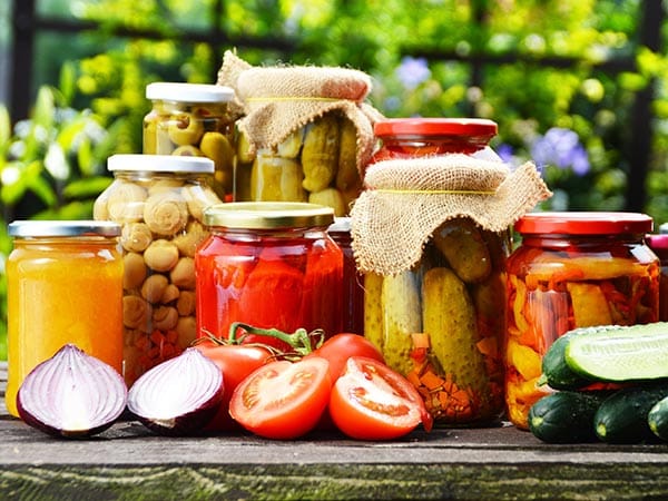 Jars of pickled vegetables in the garden. Marinated food